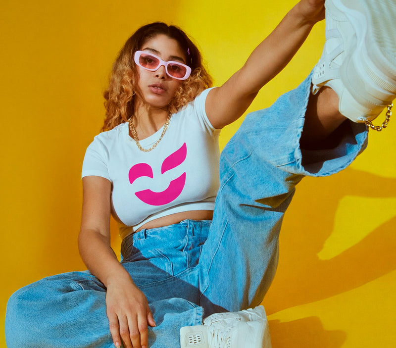 Woman seated on floor wearing a white T-shirt with the proposed Color Revolution logo