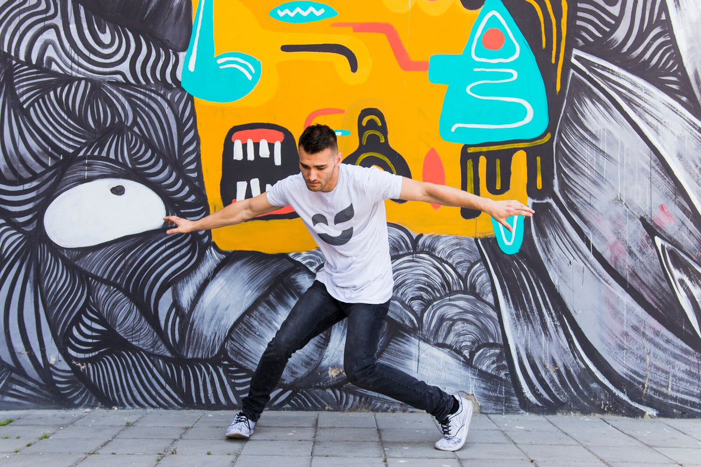 Man in front of a graffiti wall wearing a white T-shirt with the proposed Color Revolution logo